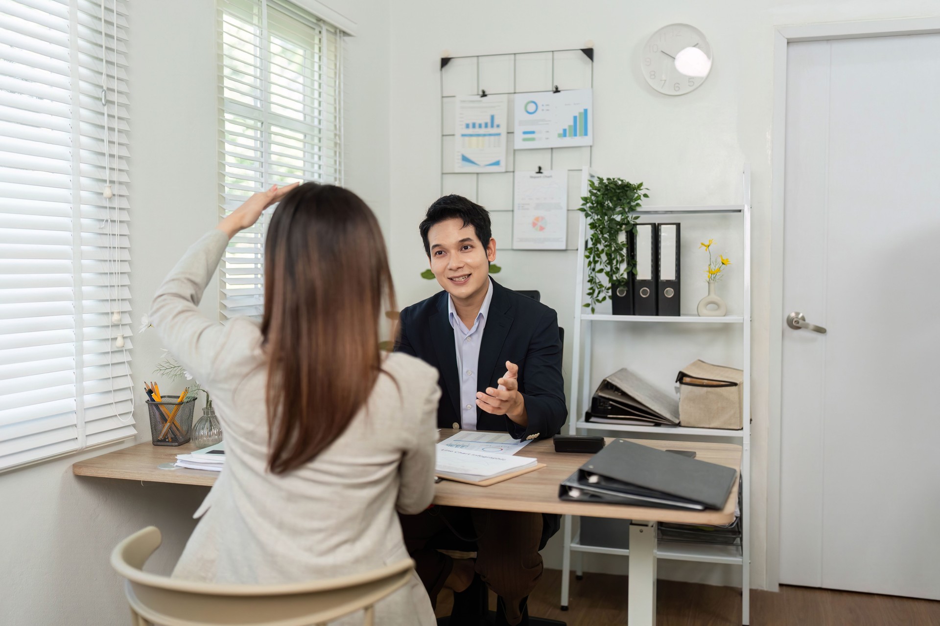 Consulta al cliente. Profesional discutiendo opciones con un cliente en una oficina moderna.