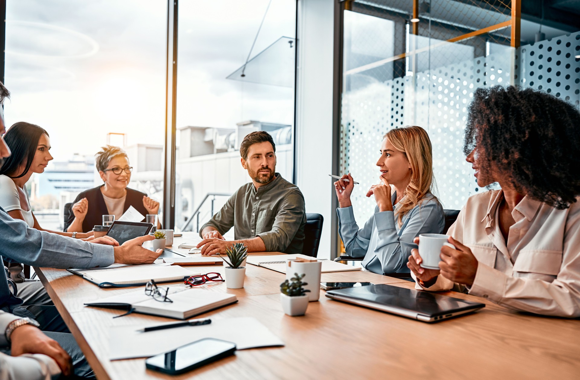 Concepto de negocio. Profesionales multinacionales, gente de negocios, discutiendo temas diarios por mesa en una oficina moderna. Reunión de negocios.
